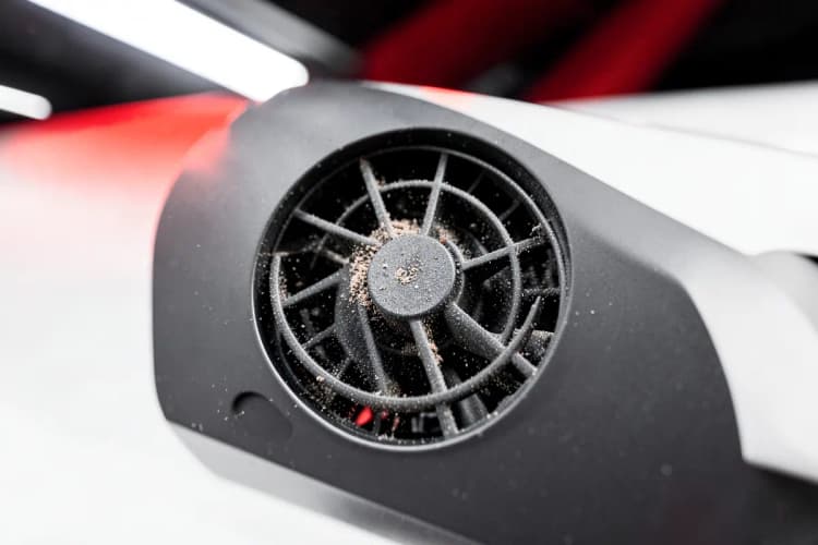 Um close-up de um ventilador de notebook com poeira acumulada.