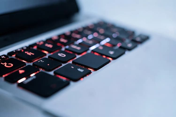 Um close-up de um notebook com várias teclas iluminadas.